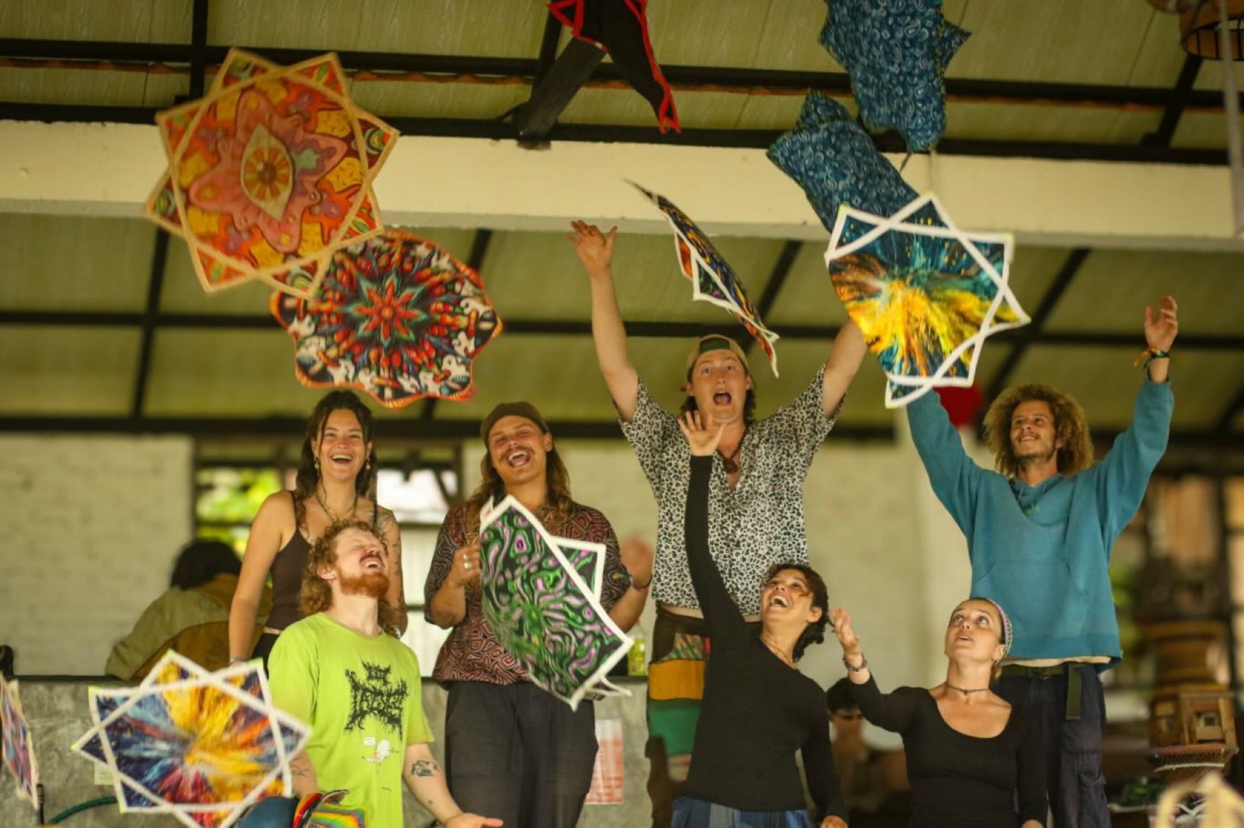 Friends laughing and tossing colourful spinning stars into the air